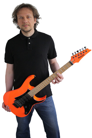 Marko Zirkovich holding an orange Ibanez electric guitar